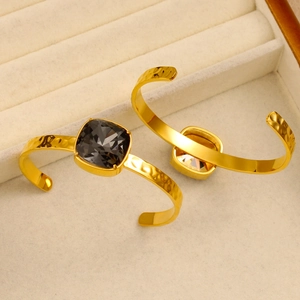 Detail of square cushion cut stones and hammered texture on 18K plated C-shape bangles