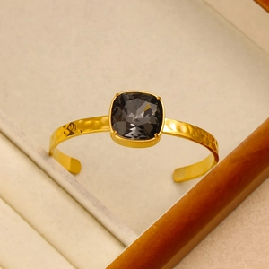 Detail of 18K gold hammered finish cuff with a square faceted dark grey crystal inlay