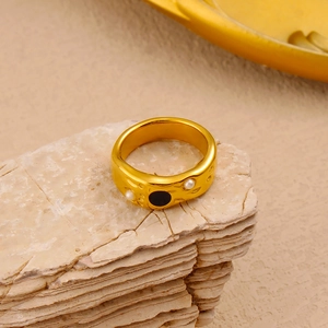 Detail view of 18K gold plated ring with lava texture, white pearls and black enamel disc