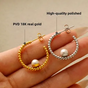 Dettaglio macro di orecchini a C con perle, finiture oro 18K e argento lucido