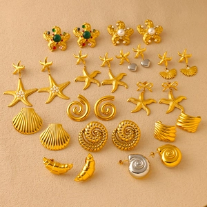Detail view of vintage ocean earrings featuring gold starfish shells and pearl accents