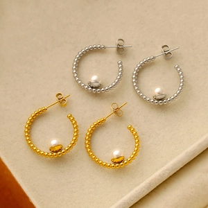 Dettaglio di orecchini di perle a forma di C in oro 18K e argento con perline in metallo