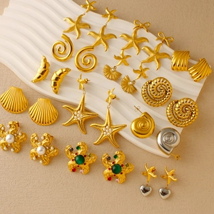 Detailed collection of gold ocean-themed earrings featuring starfish, conch and shell motifs
