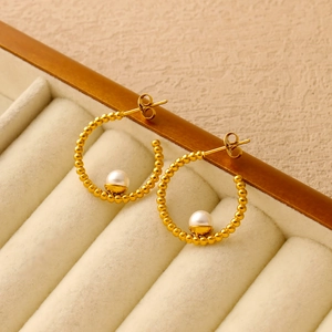 Dettaglio orecchini a cerchio a C placcati oro 18K con elegante perla bianca su velluto
