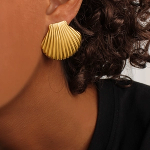Minimalist gold shell fan earrings in polished stainless steel on a model