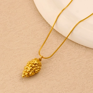 Detailed view of a gold-plated stainless steel pineapple pendant on a fine snake chain