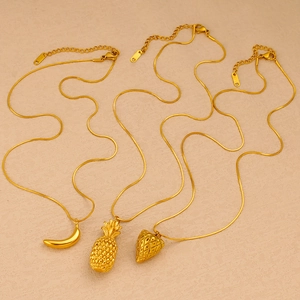 Detail of gold snake chain necklaces with banana, pineapple and strawberry fruit pendants