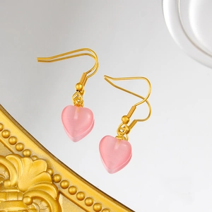 Boucles d'oreilles cœur en pierre œil de chat rose avec crochets dorés sur miroir