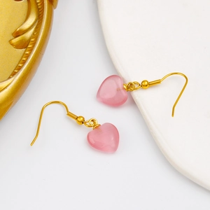 Détail des boucles d'oreilles cœur rose en pierre œil de chat avec crochets dorés