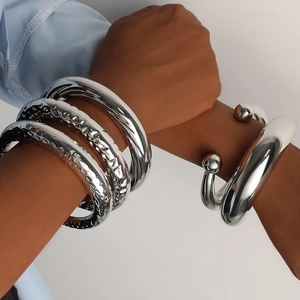 Conjunto de brazaletes en forma de C de acero inoxidable plateado en la muñeca de modelo