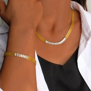 Detail of 18K gold mesh chain necklace and bracelet set with baguette-cut cubic zirconia