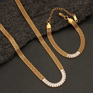 Detail of 18k gold mesh chain set with rectangular cubic zirconia on volcanic rock