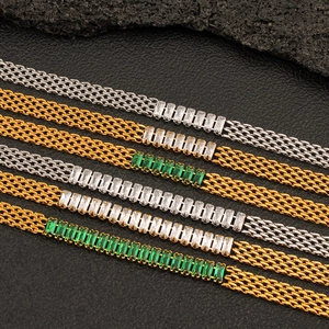Close-up of gold and silver mesh chains with rectangular green and white zircon accents
