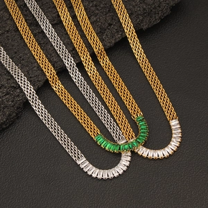 Detail view of mesh chain necklaces featuring emerald and clear baguette cut cubic zirconia