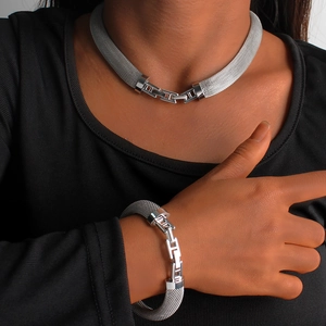 Detail of silver mesh chain necklace and bracelet set with H-shaped metal buckle on model
