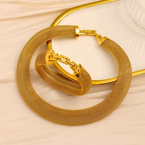 Detail of 18K gold mesh necklace and bracelet set featuring a polished square metal buckle