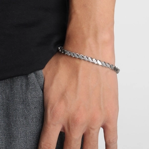 Detailed close-up of a silver stainless steel chunky chain bracelet worn on a male wrist