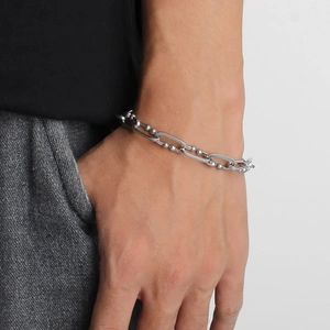 Detailed view of silver stainless steel curb chain bracelet with bead accents on wrist