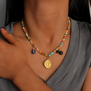 Collana boho con perline colorate, ciondolo dorato con impronte e pietra grezza blu