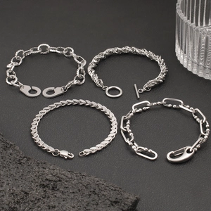 Detailed flat lay of four silver stainless steel chains including OT buckle and link styles