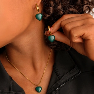Fashionable green heart pendant earrings and necklace jewelry set worn by model