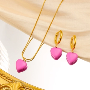 Detailed macro view of vibrant pink heart pendant jewelry set with golden snake chain necklace