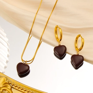 Detailed macro view of vintage heart pendant necklace and earrings on champagne satin