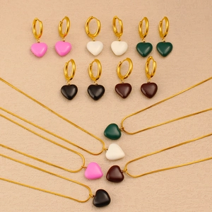 Flat lay of colorful heart jewelry sets with gold earrings and necklaces in five vibrant tones