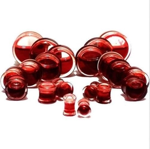Detail of clear gauges with deep red liquid filling in various sizes on white background