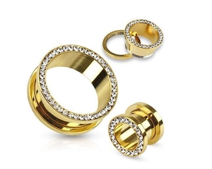 Macro view of gold stainless steel ear tunnels with sparkling rhinestones and screw fit detail