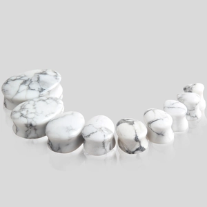 Vue détaillée d'écarteurs d'oreilles en pierre marbre blanc en forme de goutte d'eau