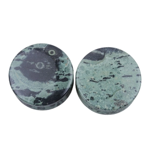 Detailed view of polished green stone ear plugs with natural black marbled pattern textures