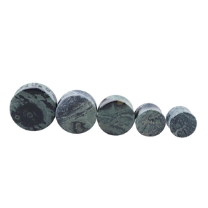 Macro view of green stone ear plugs showing various sizes and natural textures