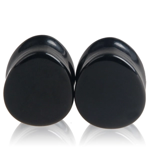 Écarteurs d'oreilles goutte en pierre noire polie avec finition miroir sur fond blanc