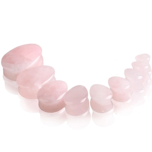 Vue détaillée d'écarteurs en quartz rose en forme de goutte et texture polie