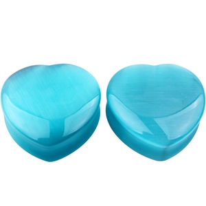 Macro detail of heart-shaped cat's eye stone ear plugs with vibrant blue silk luster
