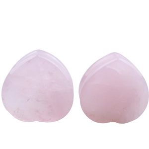 Detailed view of heart-shaped natural rose quartz ear plugs with smooth polished finish