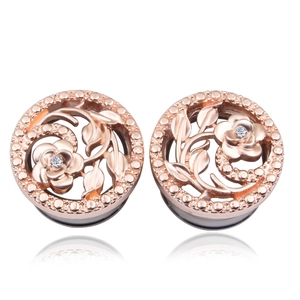 Détail de l'écarteur d'oreille ajouré or rose avec motif fleur et pierre de zircon