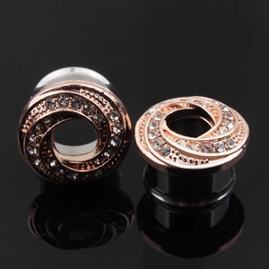 Makroaufnahme von roségoldenem Ohrtunnel mit Zirkonia-Kristallen und elegantem Spiralmuster