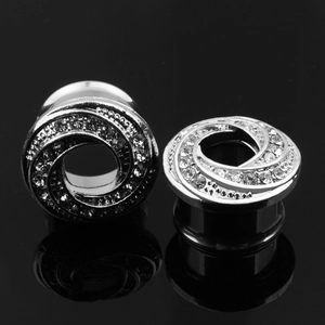 Detailansicht silberner Spiral-Ohr-Plugs mit funkelnden weißen Strasssteinen aus Edelstahl