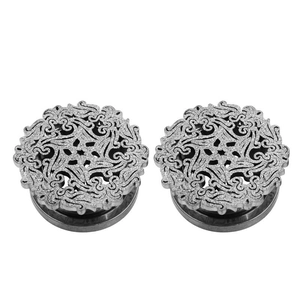 Detailed close-up of hollow floral pattern on silver matte stainless steel ear plugs
