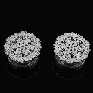 Close-up of silver hollow-out ear plugs with vintage frosted finish and floral design
