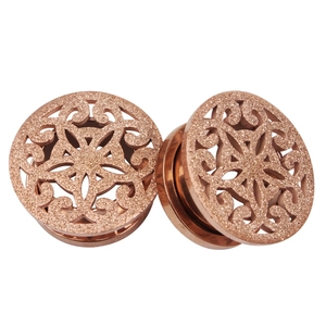 Makroaufnahme der roségoldenen Edelstahl-Ear-Gauges mit Mandala-Ausschnitt und Glitzer