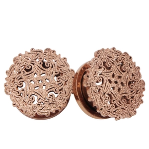 Detailed view of rose gold hollow out ear gauges with glitter finish and scroll pattern