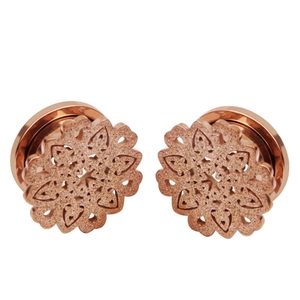 Détail de l'écarteur d'oreille rose doré avec motif mandala et fini pailleté
