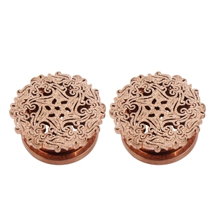 Macro detail of rose gold hollow mandala stainless steel ear plugs with intricate patterns