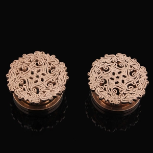 Detailed close-up of rose gold hollow mandala pattern on stainless steel ear tunnels
