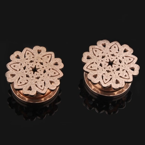 Élargisseurs d'oreilles rose doré à motif floral creux avec finition mate sur fond noir