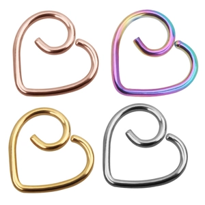 Detail of heart-shaped surgical steel helix piercing rings in gold, silver, and rose gold
