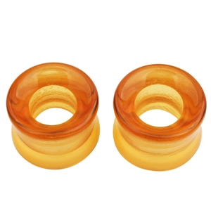 Détails macro d'écarteurs d'oreilles en verre ambré translucide avec finition lisse